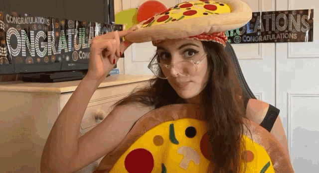 a woman wearing a hat that looks like a pizza and a sign that says congratulations