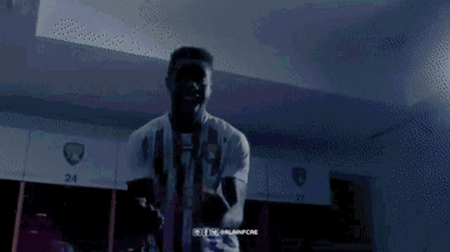 a soccer player in a locker room with a medal around his neck .