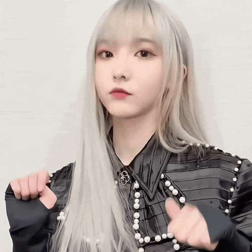 a girl with long white hair is wearing a black shirt and pearls