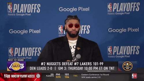 a man stands in front of a playoffs banner