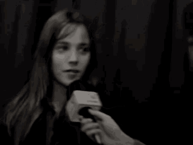 a black and white photo of a woman talking into a microphone with the number 3 on the side