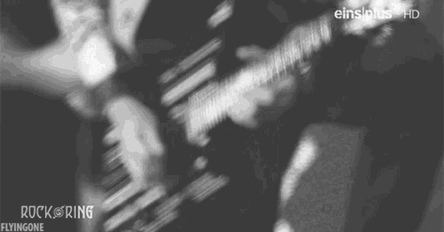 a black and white photo of a person playing a guitar with the words rock flyingone on the bottom right