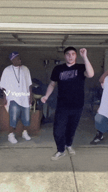 a group of men are dancing in a garage and one of them is wearing a black shirt that says mafia
