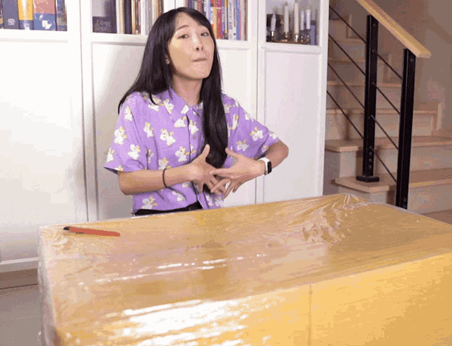 a woman in a purple shirt is sitting at a table