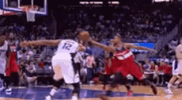 a group of basketball players are playing a game of basketball in a stadium .