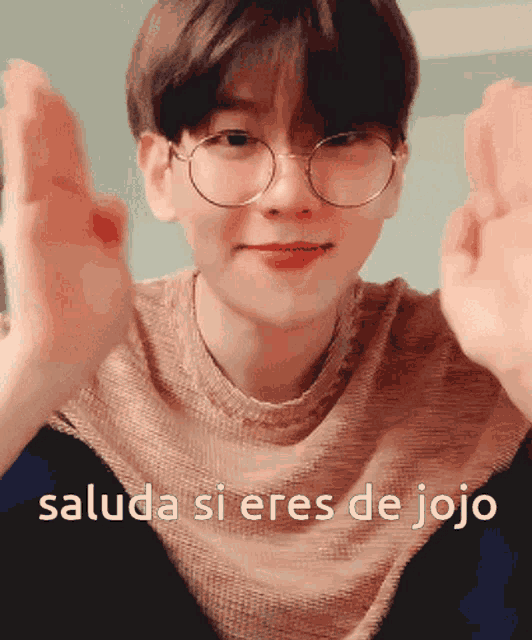 a young man wearing glasses says " saluda si eres de jojo " in front of his face