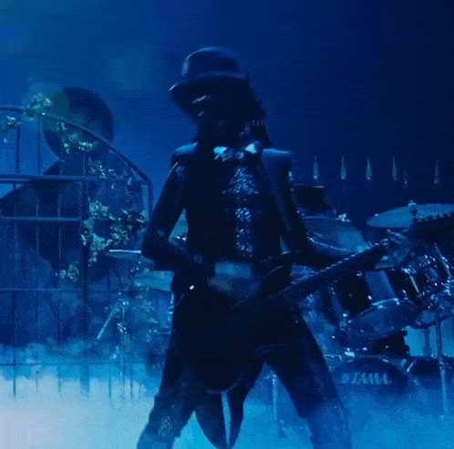 a man playing a guitar in front of a drum set that says tama
