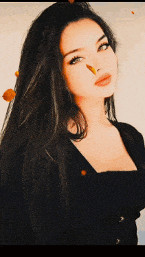 a woman with long black hair and blue eyes is wearing a black top