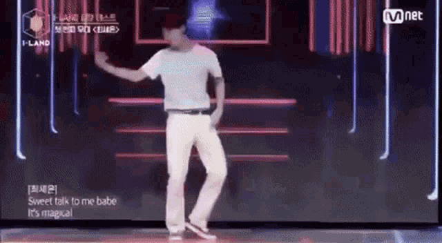 a man is dancing on a stage while wearing a white shirt .