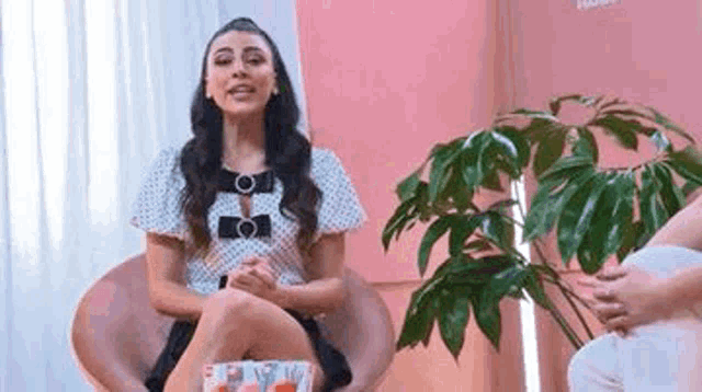 a woman is sitting in a chair talking to another woman .