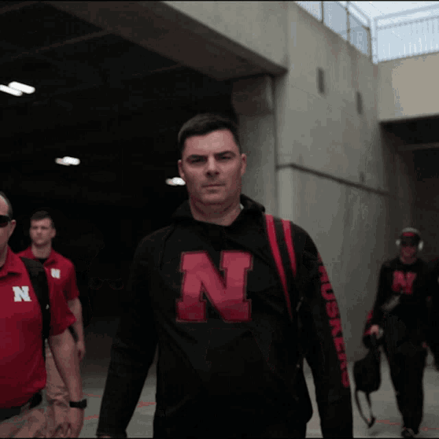 a man wearing a black shirt with the letter n on the front