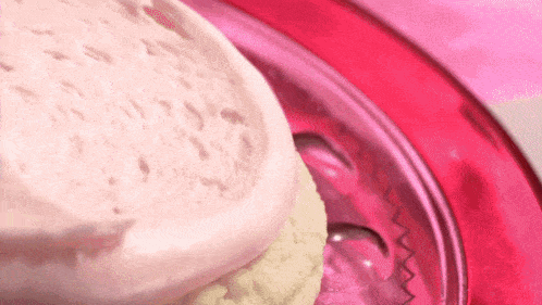 a close up of a pink plate with a cupcake on it