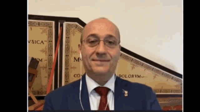 a man in a suit and tie is smiling in front of a map with the word dolorvm on it