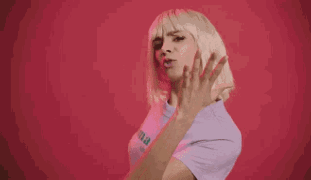 a woman with blonde hair is wearing a purple t-shirt with the word dimanche on it .