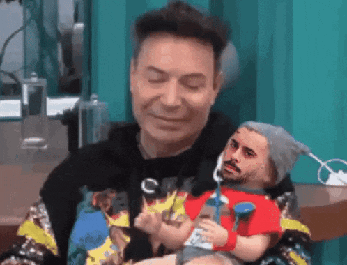 a man is holding a doll with a face on it
