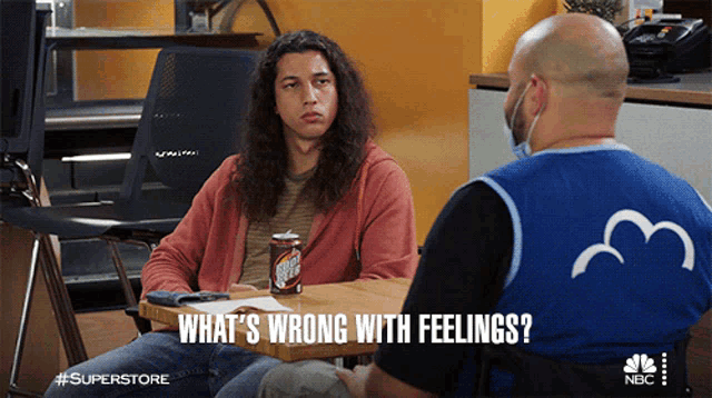 a man with long hair is sitting at a table with a can of sierra mist