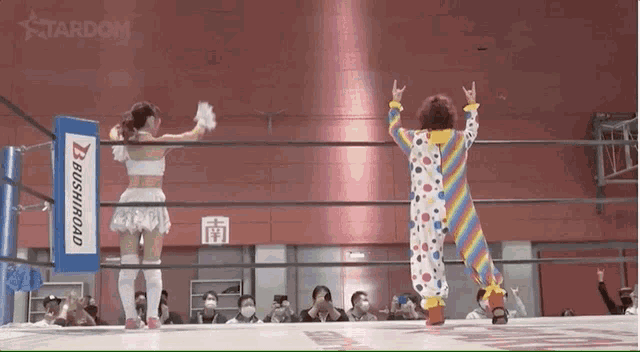 a clown is standing in a wrestling ring next to a woman in a white dress .