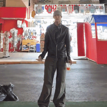 a man is standing in front of a store that has a sign that says ' t-shirts ' on it