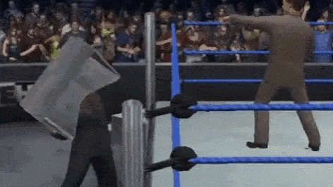 a man in a suit is standing in a wrestling ring holding a bag over his head .