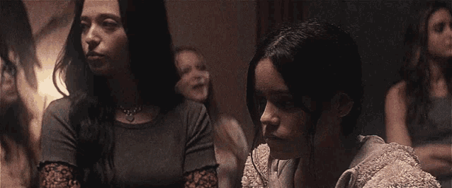 two women are sitting next to each other in a room .
