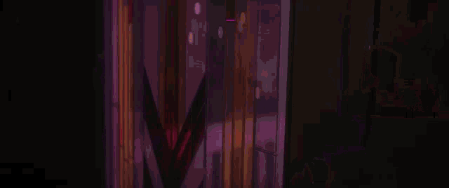 a man is laying on a woman 's chest in a dark room with purple lights .