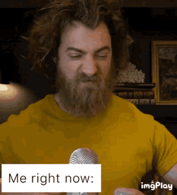 a man with a beard is talking into a microphone with the words me right now below him