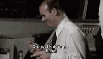 a man in a white shirt and tie is standing in front of a steering wheel and talking .