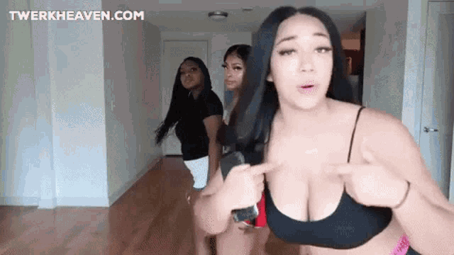 three women are standing next to each other in a living room .