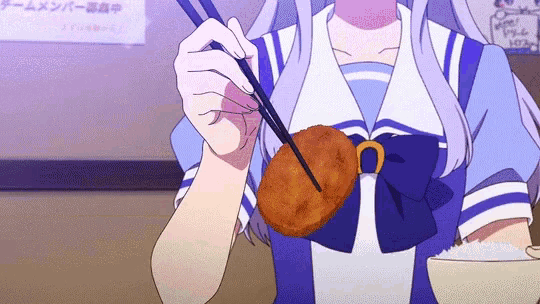 a girl in a blue and white uniform is eating a fried food with chopsticks