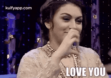 a woman is covering her mouth with her hand while saying `` love you '' .