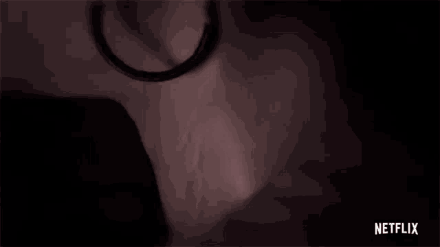 a close up of a woman 's face with a netflix logo behind her
