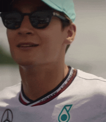 a man wearing sunglasses and a shirt that says petronas