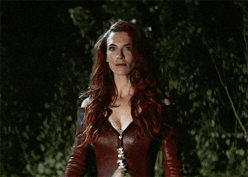a woman with red hair is holding a purple object