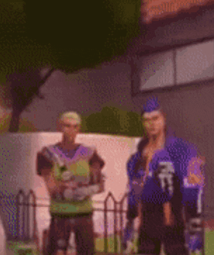 a couple of men standing next to each other in front of a building .