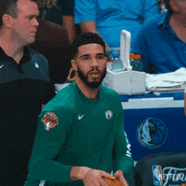 a man wearing a green shirt with the word netflix on the front