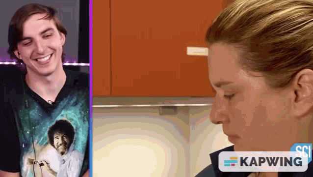 a man wearing a bob ross shirt is smiling next to a woman who is crying