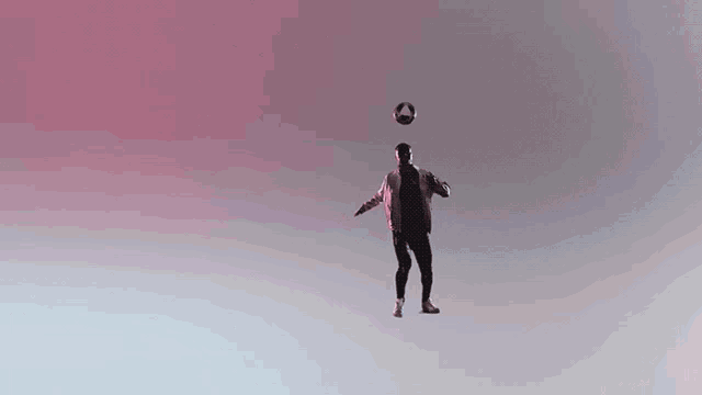 a man is juggling a soccer ball on his head .
