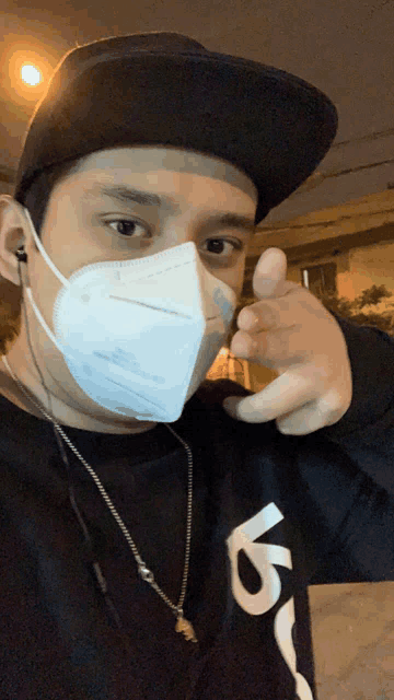 a man wearing a mask and a black shirt with the letter v on the front