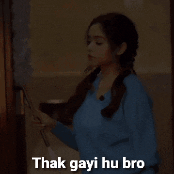 a woman in a blue sweater is cleaning a door with a duster and the words " thak gayi hu bro " above her