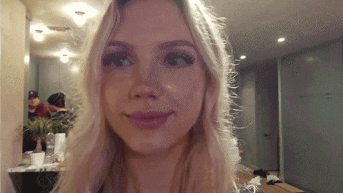 a woman with blonde hair is looking at the camera