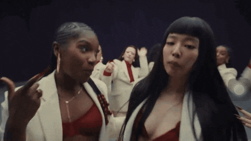 two women are standing next to each other and one of them is wearing a red bra