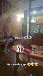 a man standing in a living room with the words ta godzina 22:00 xd
