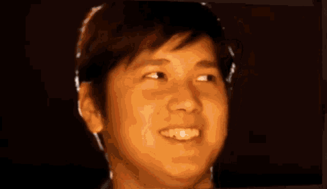 a close up of a young man 's face with a light shining on his face .