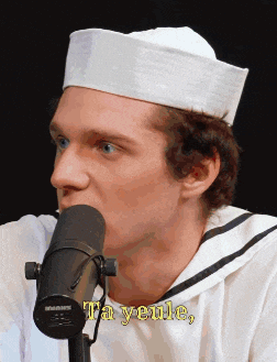 a man wearing a sailor hat is talking into a microphone with the words ta yeule written on the bottom