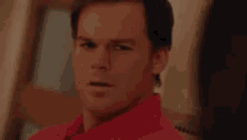 a man in a red shirt is sitting in a chair and saying i 'm so fucking happy for you