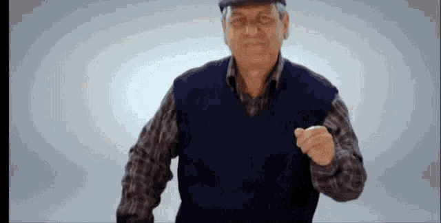 a man wearing a hat and a vest is pointing his finger