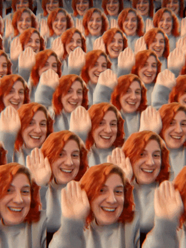 a bunch of women with red hair are smiling and raising their hands