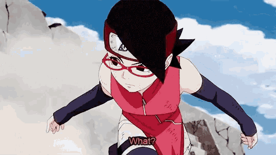a girl wearing glasses and a red shirt is standing on top of a rock .