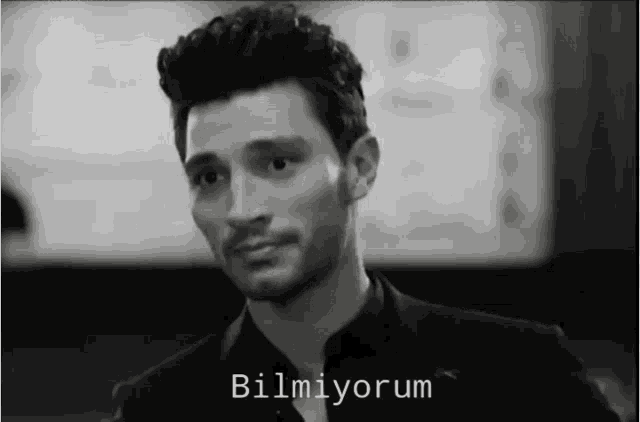 a black and white photo of a man with the words bilmiyorum written on the bottom
