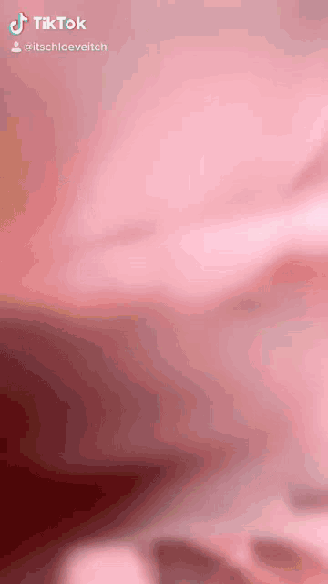 a close up of a pink background with tiktok written on the bottom right